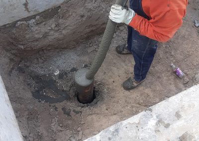 Filling the helical pile with grout.